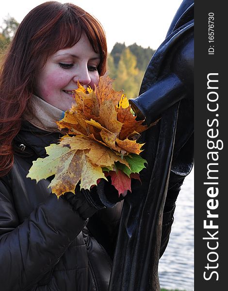 The girl is holding autumn leaves