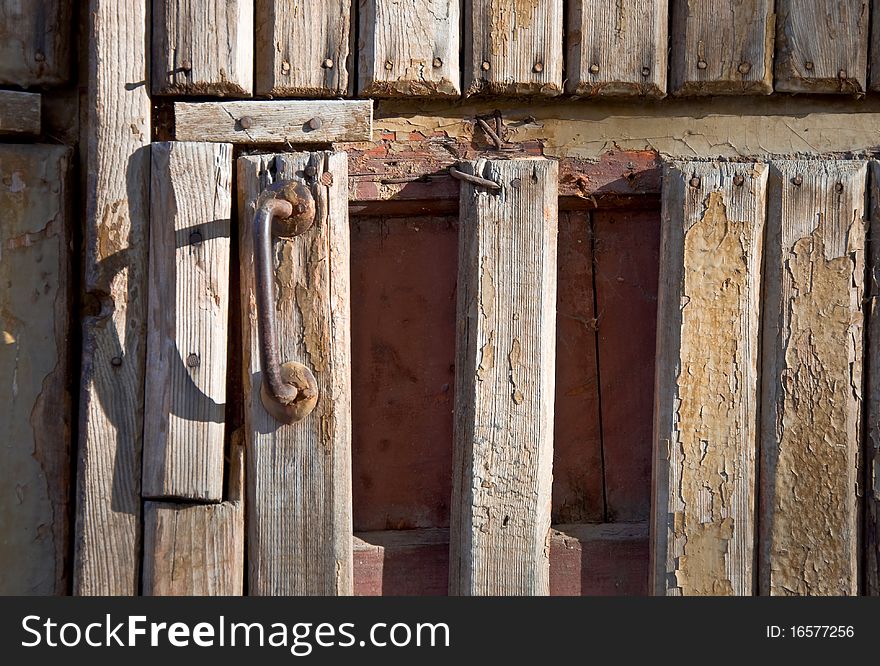 Fragment of an old wooden door with a handle. Close-up, front.