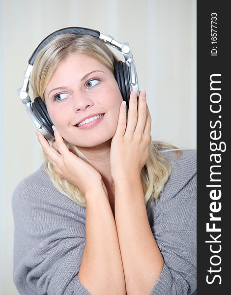 Beautiful blond woman at home with headphones on. Beautiful blond woman at home with headphones on