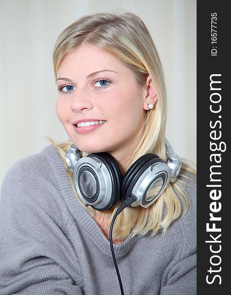 Beautiful blond woman at home with headphones on. Beautiful blond woman at home with headphones on