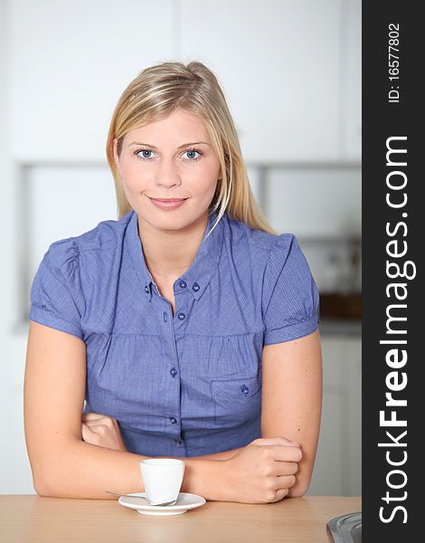 Smiling beautiful blond woman standing in kitchen. Smiling beautiful blond woman standing in kitchen