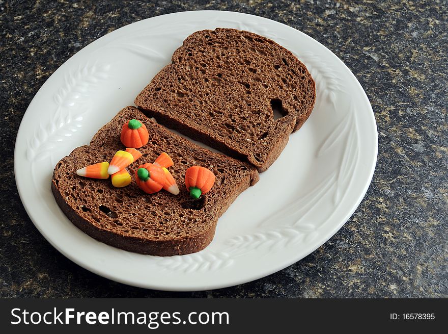 An unhealthy halloween snack. A candycorn and bread sandwich!