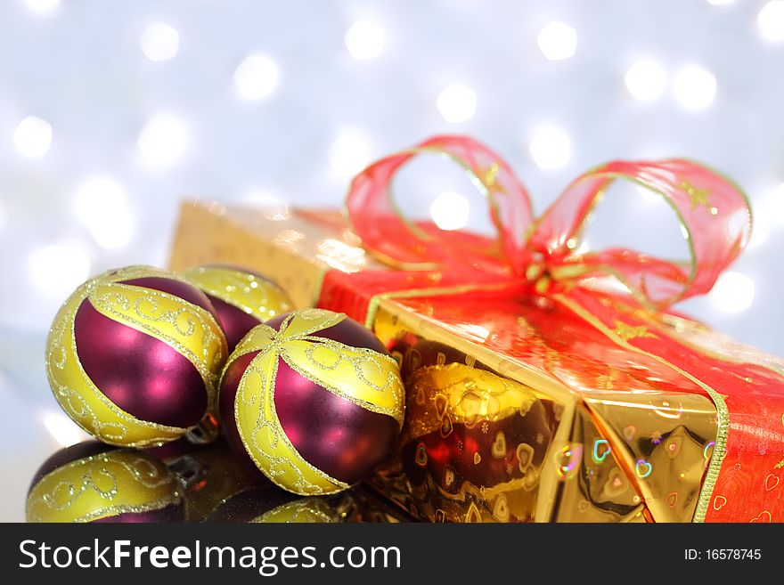 Christmas balls and gift box on the background lights