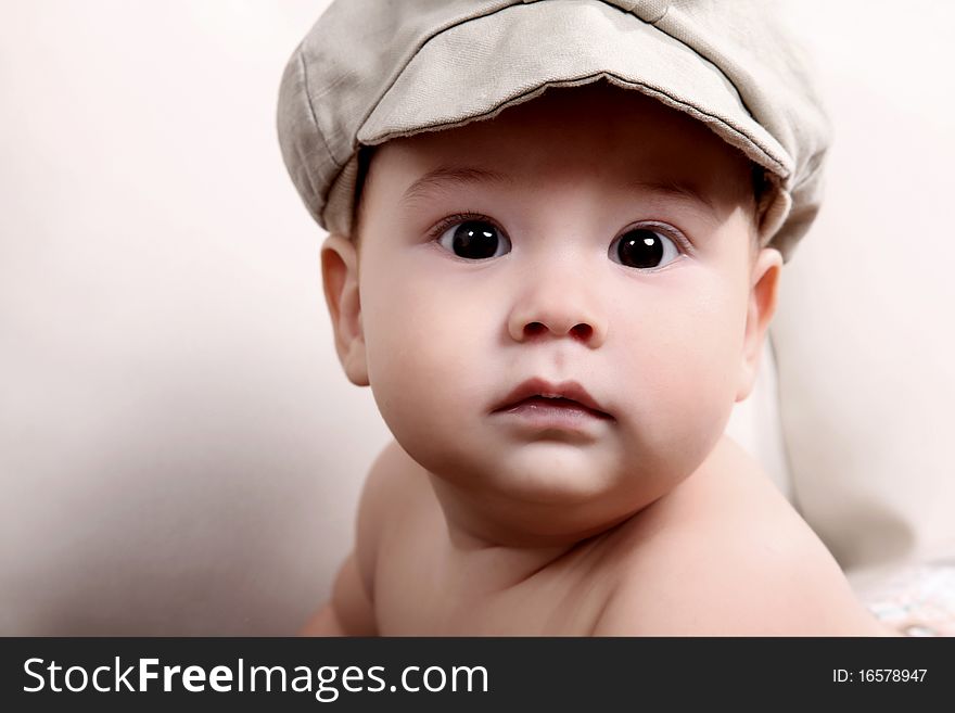 Baby looking at the camera with gray beret