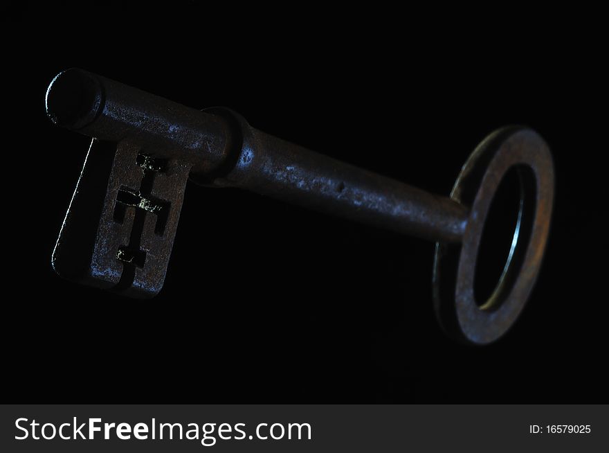 An Old Rusty Key On A Black Background. An Old Rusty Key On A Black Background.
