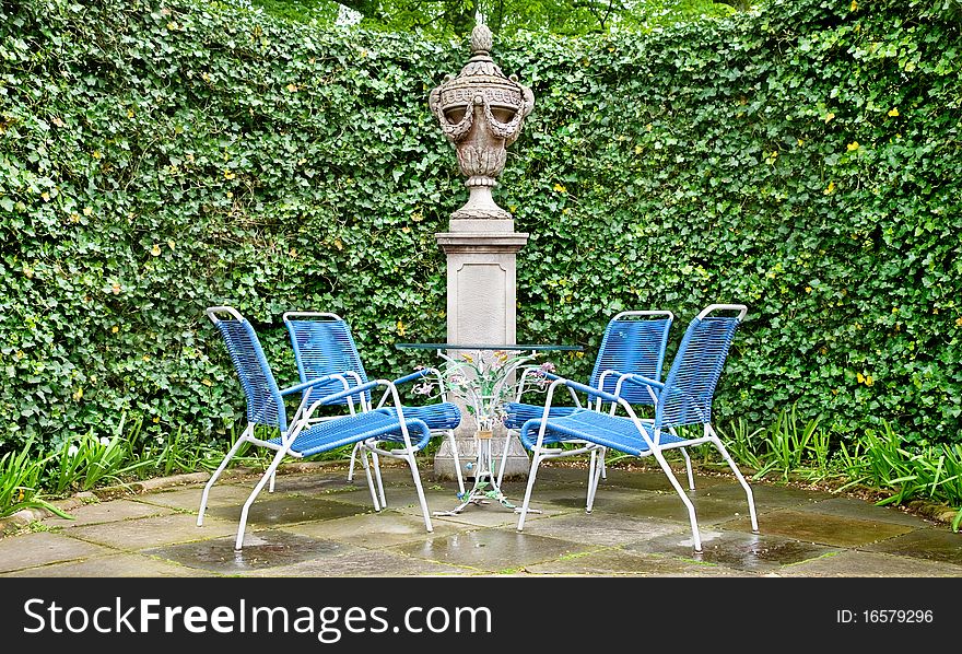 Four wicker chairs and glass table in the garden