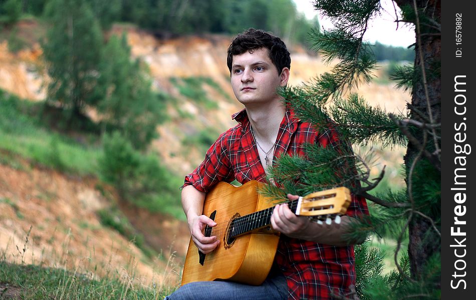 A lone young man with a guitar. A lone young man with a guitar