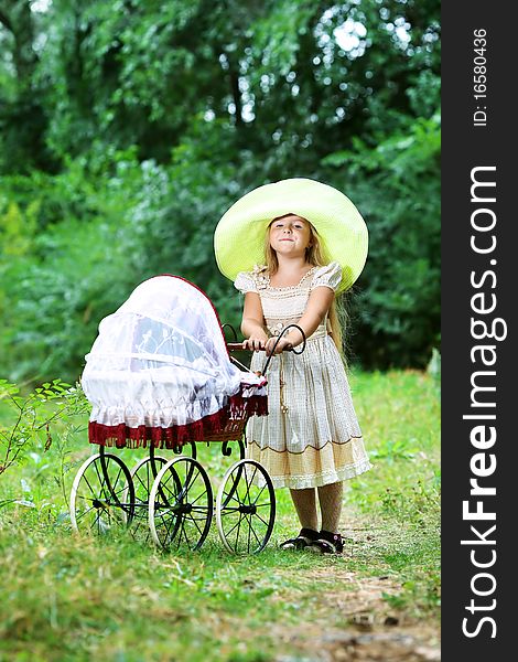 Shot of a cute girl walking with baby buggy at summer park. Shot of a cute girl walking with baby buggy at summer park.