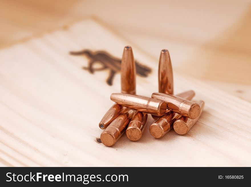 Bullets lying and standing on a wooden surface. Bullets lying and standing on a wooden surface.