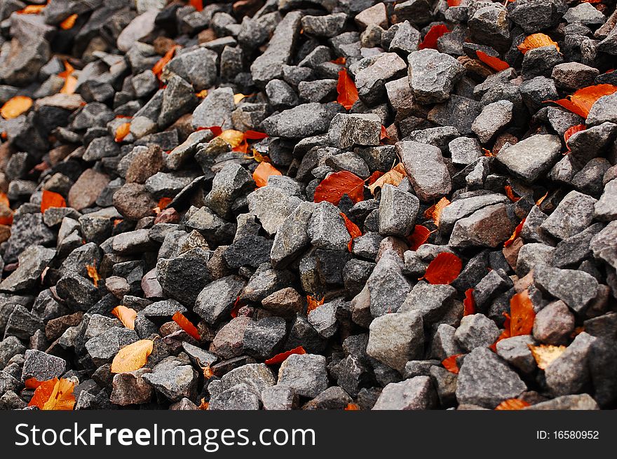 Autumn leaves among gravel rocks