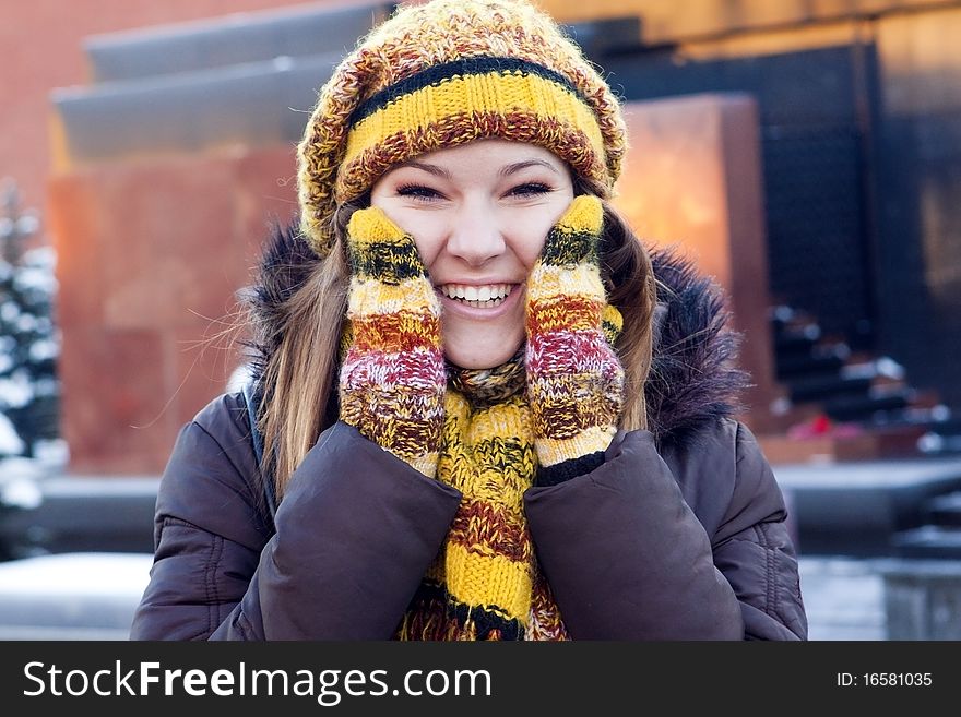 Cheerful girl in winter hat and mittens