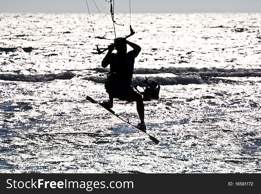 Silhouette of a kitesurfer jumping in the waves. Silhouette of a kitesurfer jumping in the waves