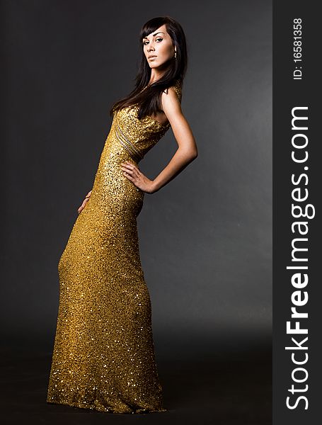 Beautiful fashionable woman in golden dress