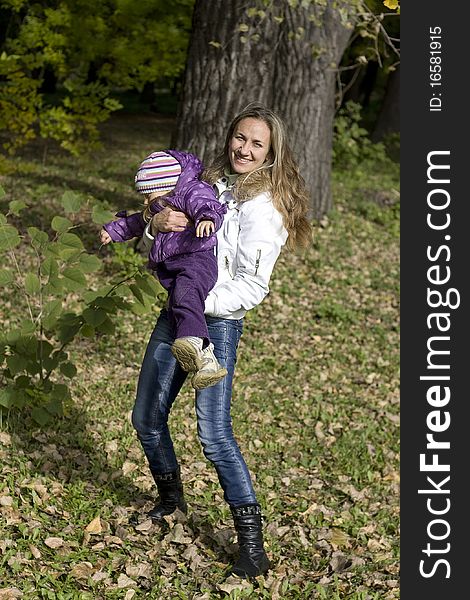 Mom and daughter having fun in autumn park