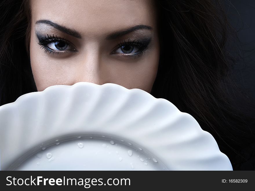 Glamour woman with a white porcelain plate in hands