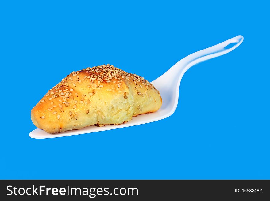Hot fresh baked pastry with sesame seeds isolated on blue