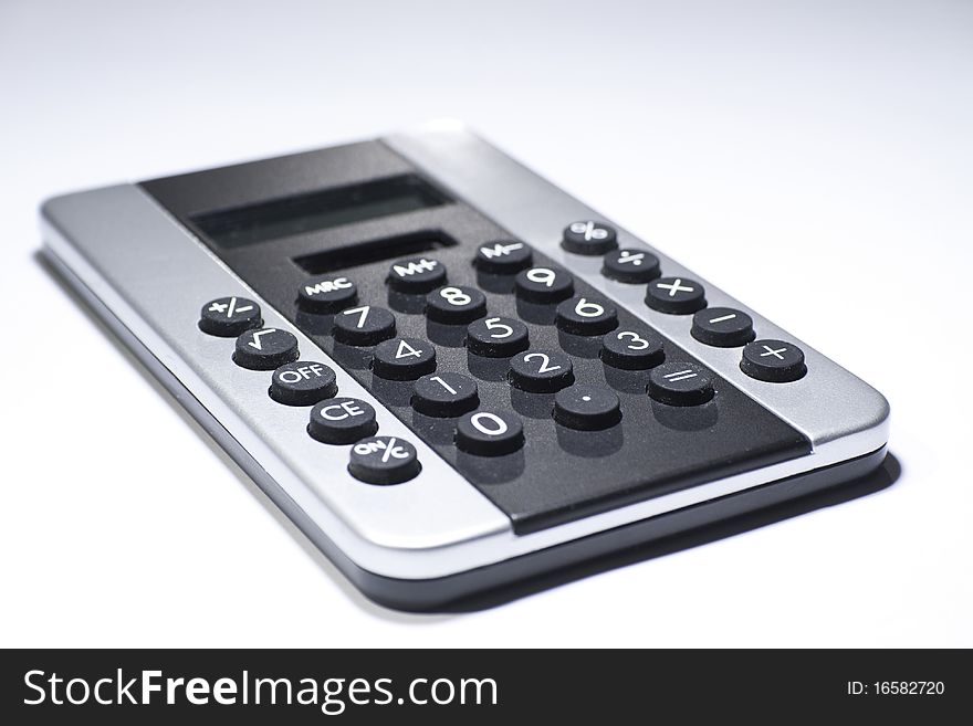 Black-silver pocket calculator on a white background, studio photo