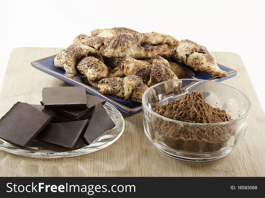 Chocolate Rugelach pastries with chunks of chocolate and bowl of cocoa.