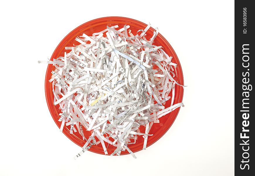 Red plastic dish full of paper strips on the white background