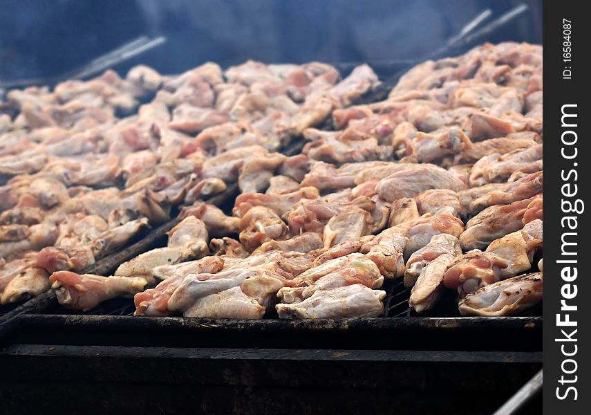 Smoke infused chicken wings cooking on a fire barbecue grill. Smoke infused chicken wings cooking on a fire barbecue grill.