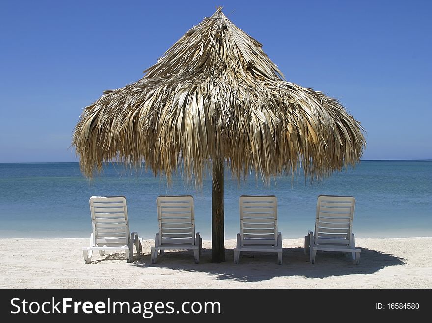 Four chairs and palapa in front of the ocean
