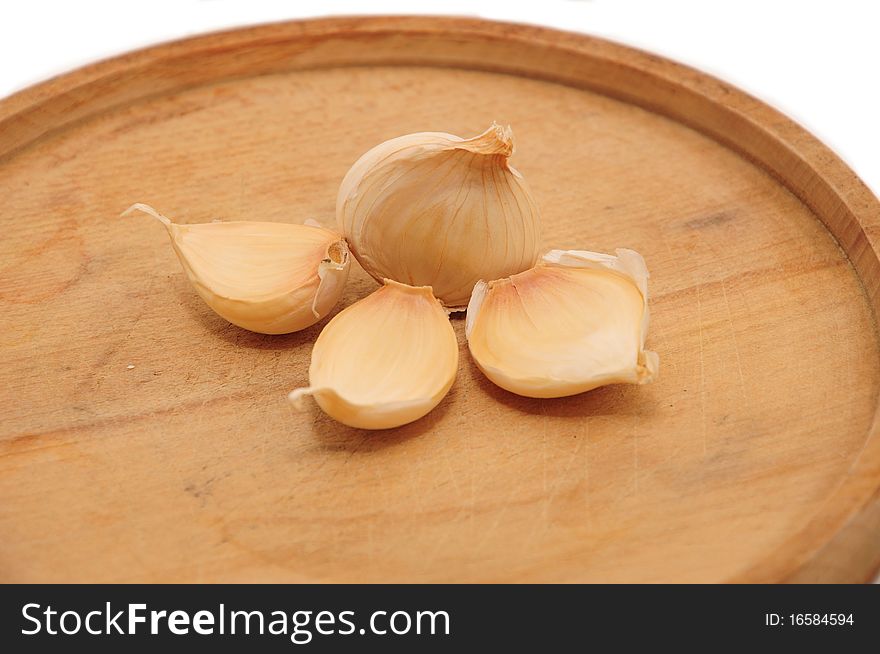 Heads of garlic on a wooden plate