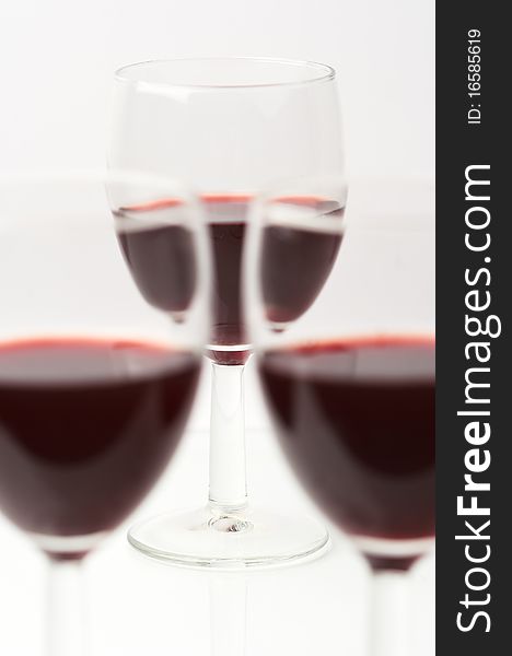 Three glasses with red wine on white. Three glasses with red wine on white.