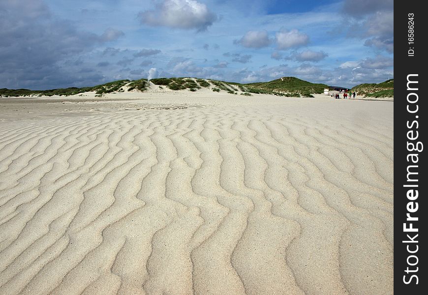 Long beach on the island of amrum with dunes in the back and paterns in the sand