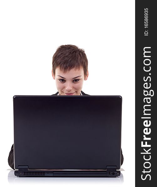 Attractive smiling young business woman using laptop at work desk