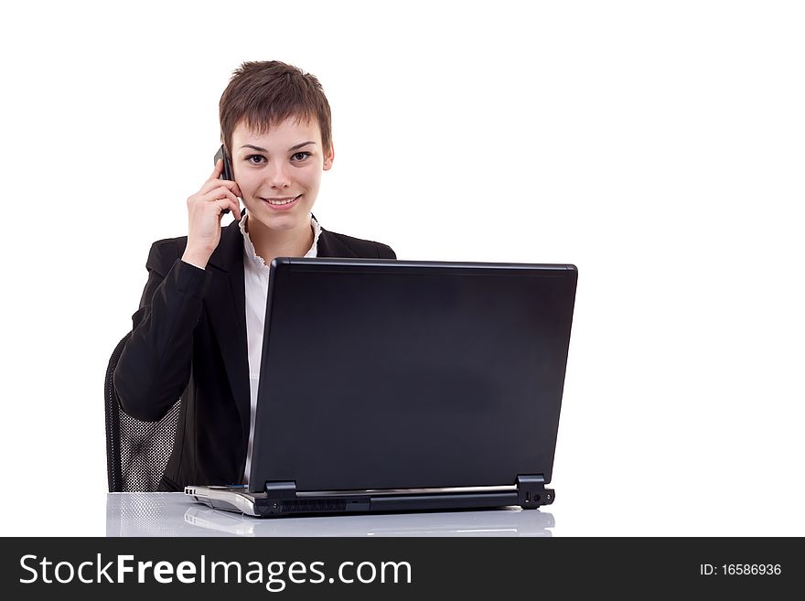 Beautiful woman with a mobile phone talking at her desk. Beautiful woman with a mobile phone talking at her desk