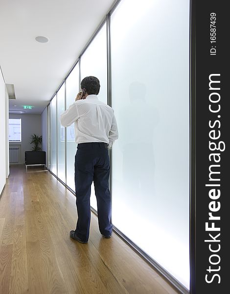 Businessman talking on mobile phone in office lobby