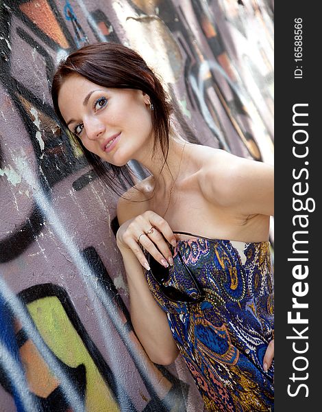 Young attractive woman near the wall with graffiti