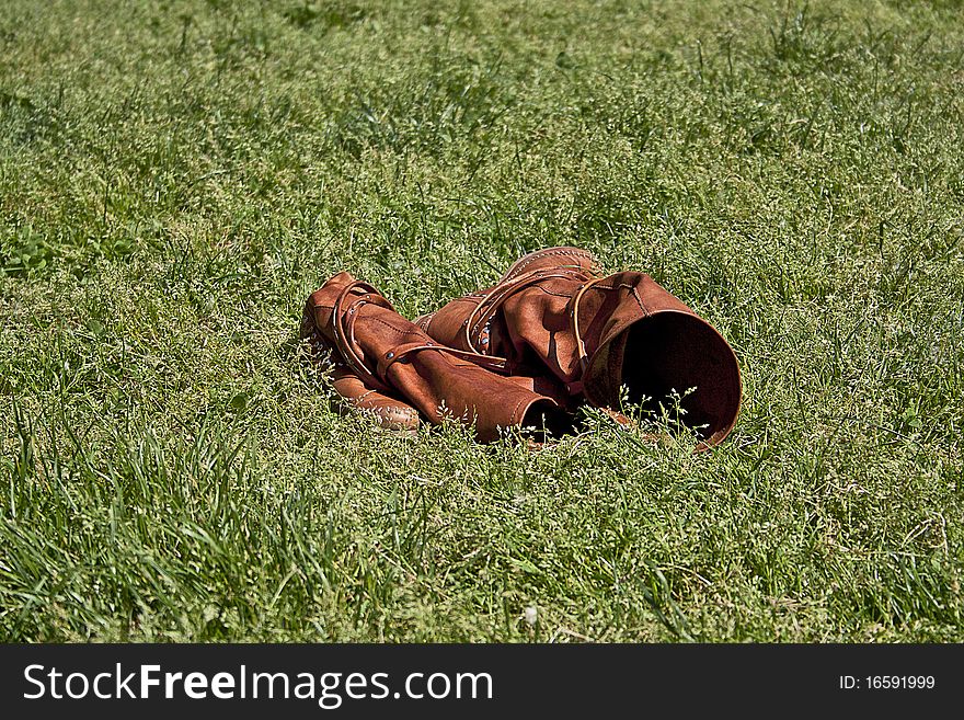 Boots in the grass on a sunny day illuminated by the sun of summer. Boots in the grass on a sunny day illuminated by the sun of summer