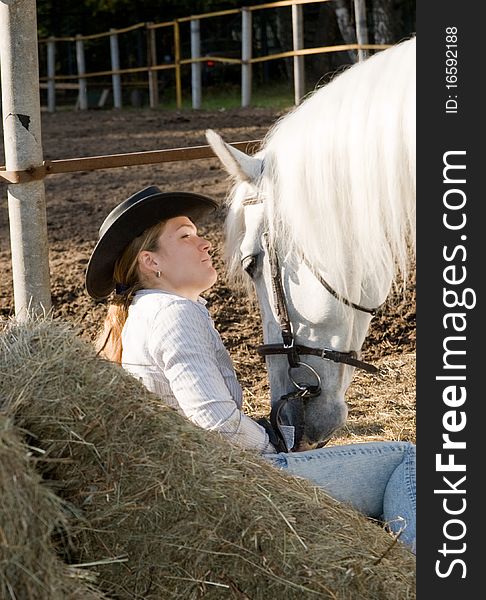 Portrait of young woman with her white horse on the farm yard. Portrait of young woman with her white horse on the farm yard