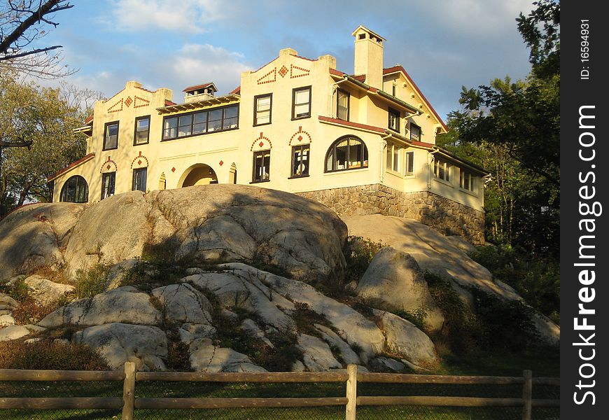 A beautiful building sits high on the rocks in the afternoon sunshine.