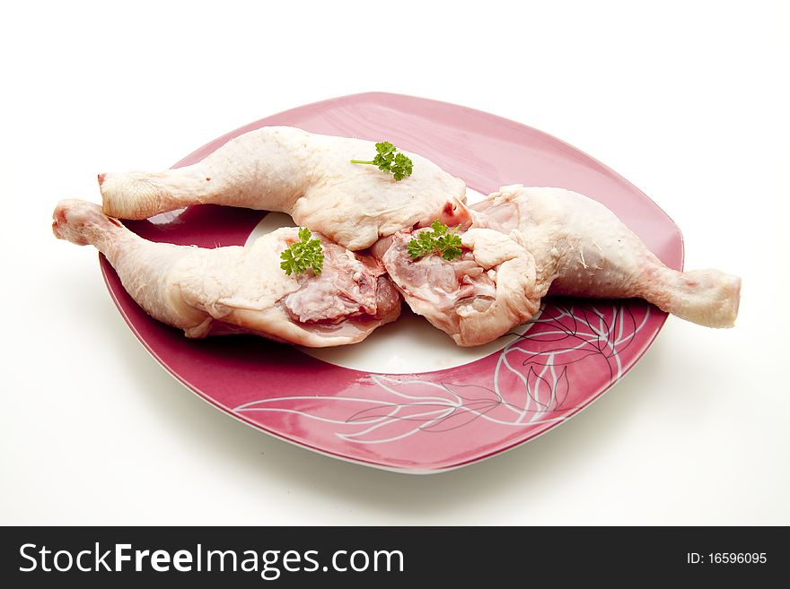 Chicken thigh raw with parsley and onto plates