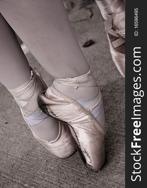 Pointe shoes showing wear while a ballet dancer is in releve position. Pointe shoes showing wear while a ballet dancer is in releve position