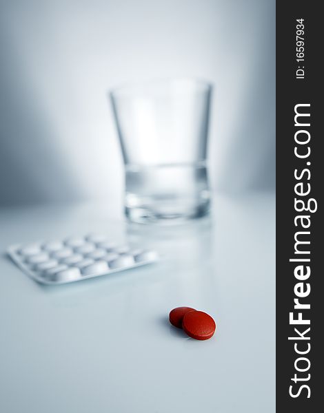 Medical Red Pill And Aspirin With Water And Glass