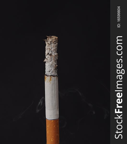 Lit cigarette on a black background