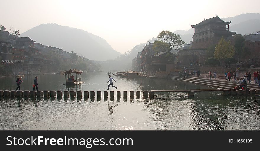 Chinse folk crossing bridge make from many stones in old village. Chinse folk crossing bridge make from many stones in old village