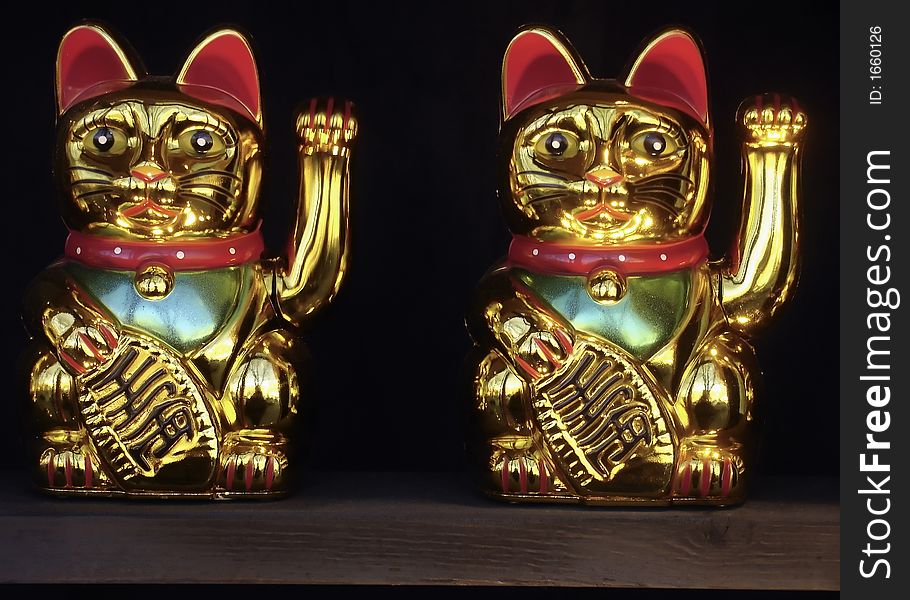 A pair of chinese ornamental happy and cute cats. A pair of chinese ornamental happy and cute cats