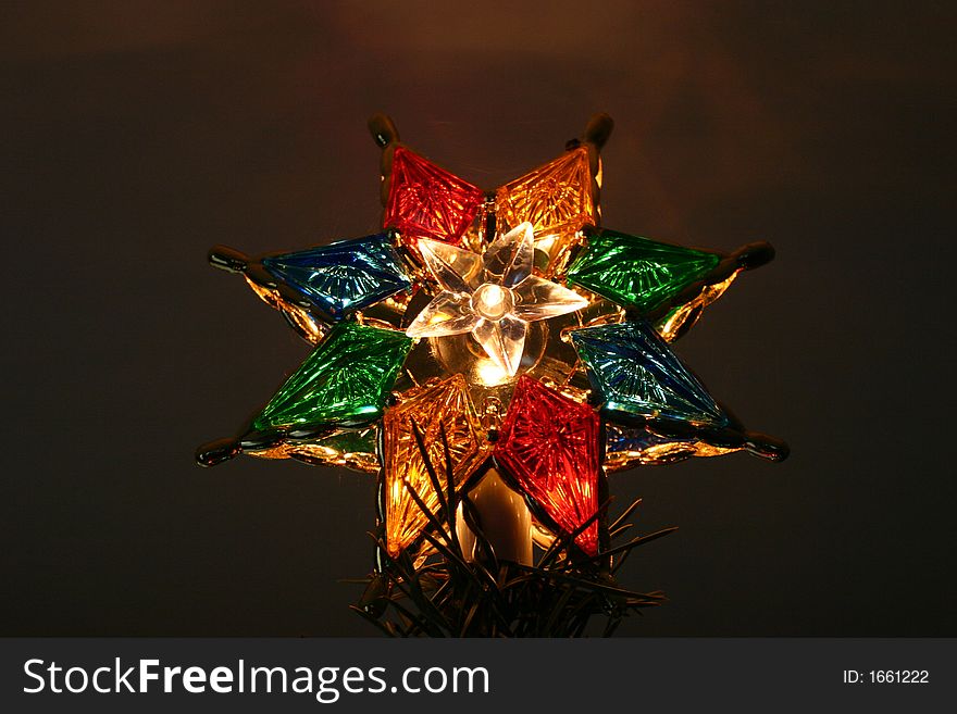 Closeup of a christmas tree star high atop a tree