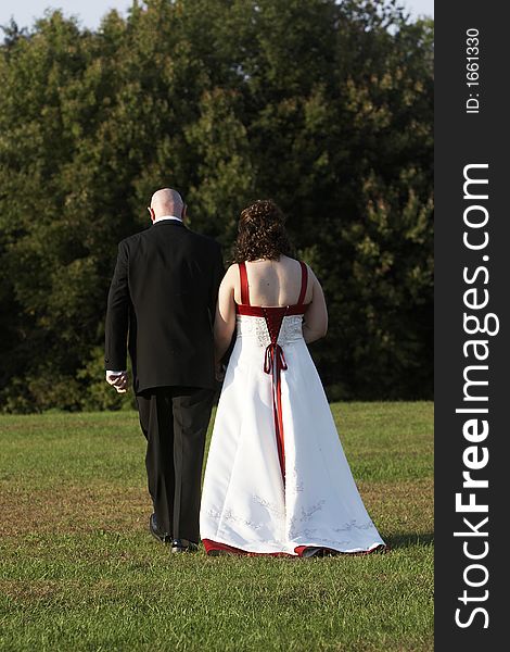 A bride and groom walking away from the camera. A bride and groom walking away from the camera.