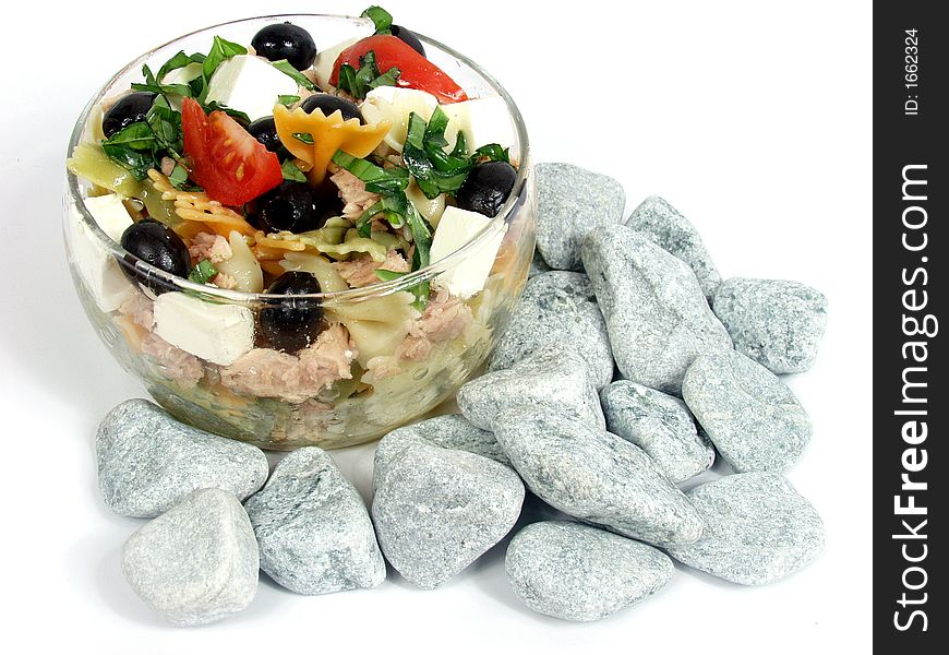 Pasta salad on glass bowl with fetta cheese and olives