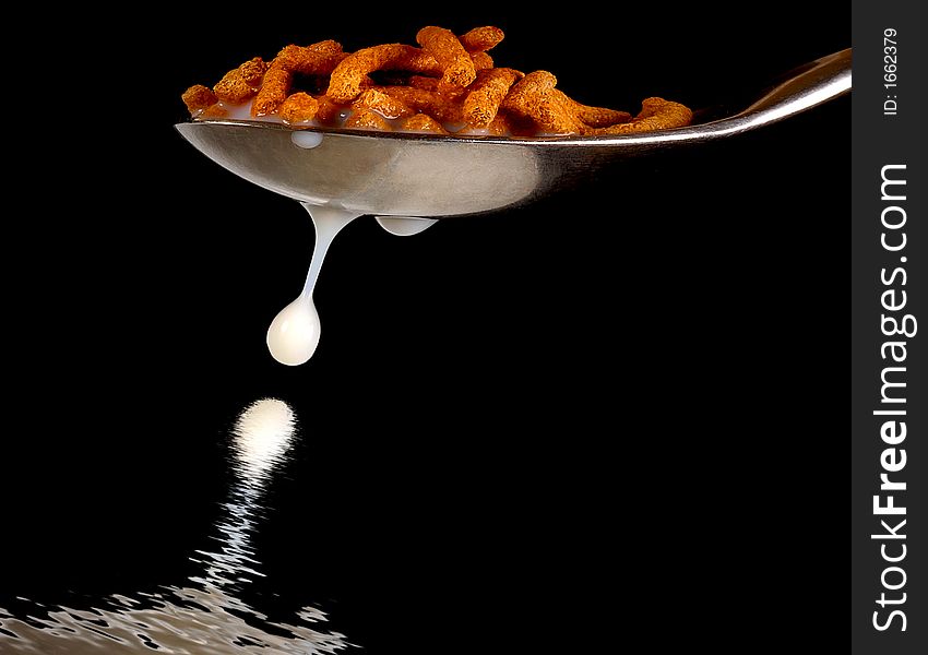 Spoon with Cereal and Milk dripping On Black. Spoon with Cereal and Milk dripping On Black