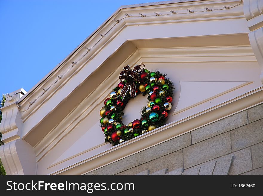 A red, green, blue christmas wreath on a building