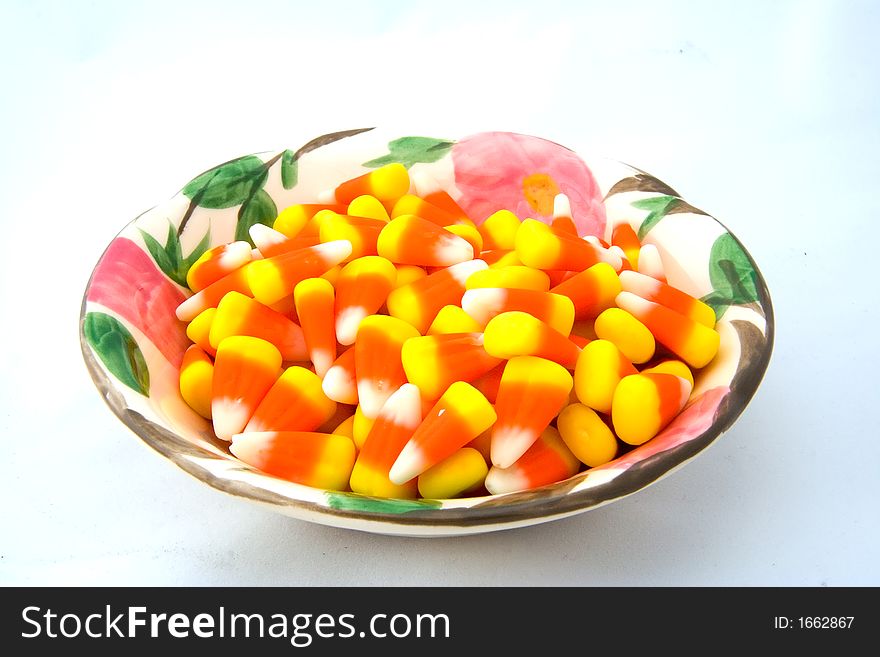 Bowl of candy corn on a white background.