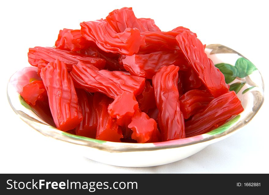 Bowl of raspberry candy on a white background.