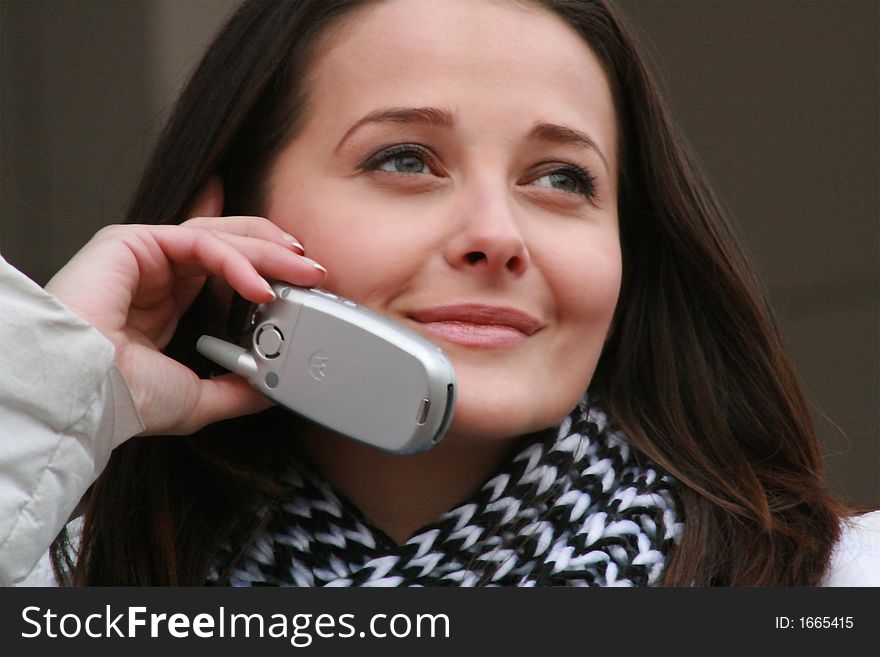 Portrait of a beutiful woman talking on the cell phone and looking far away smiling. Portrait of a beutiful woman talking on the cell phone and looking far away smiling