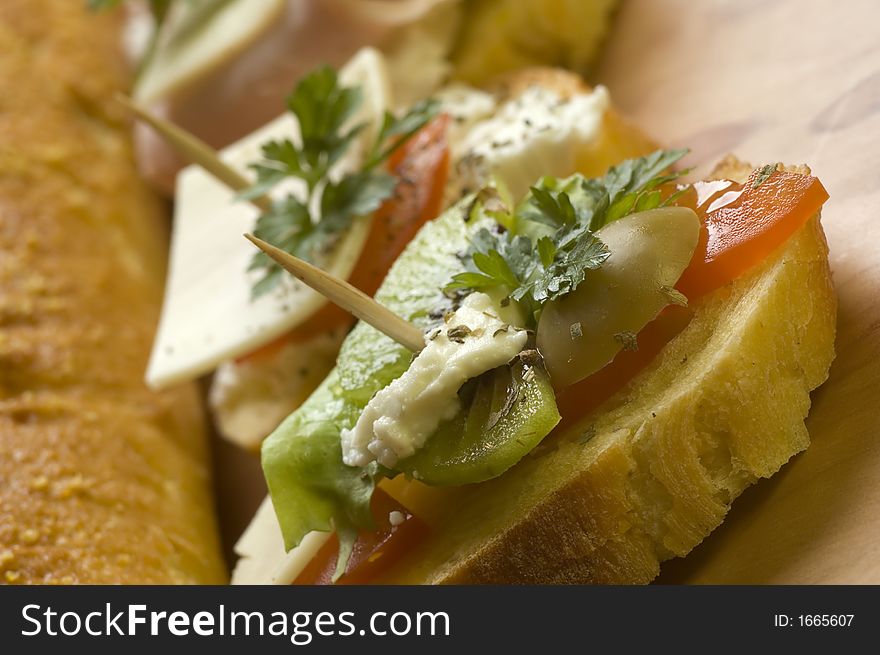 Small sandwich with tomato, cheese, kiwi and olive close up. Small sandwich with tomato, cheese, kiwi and olive close up